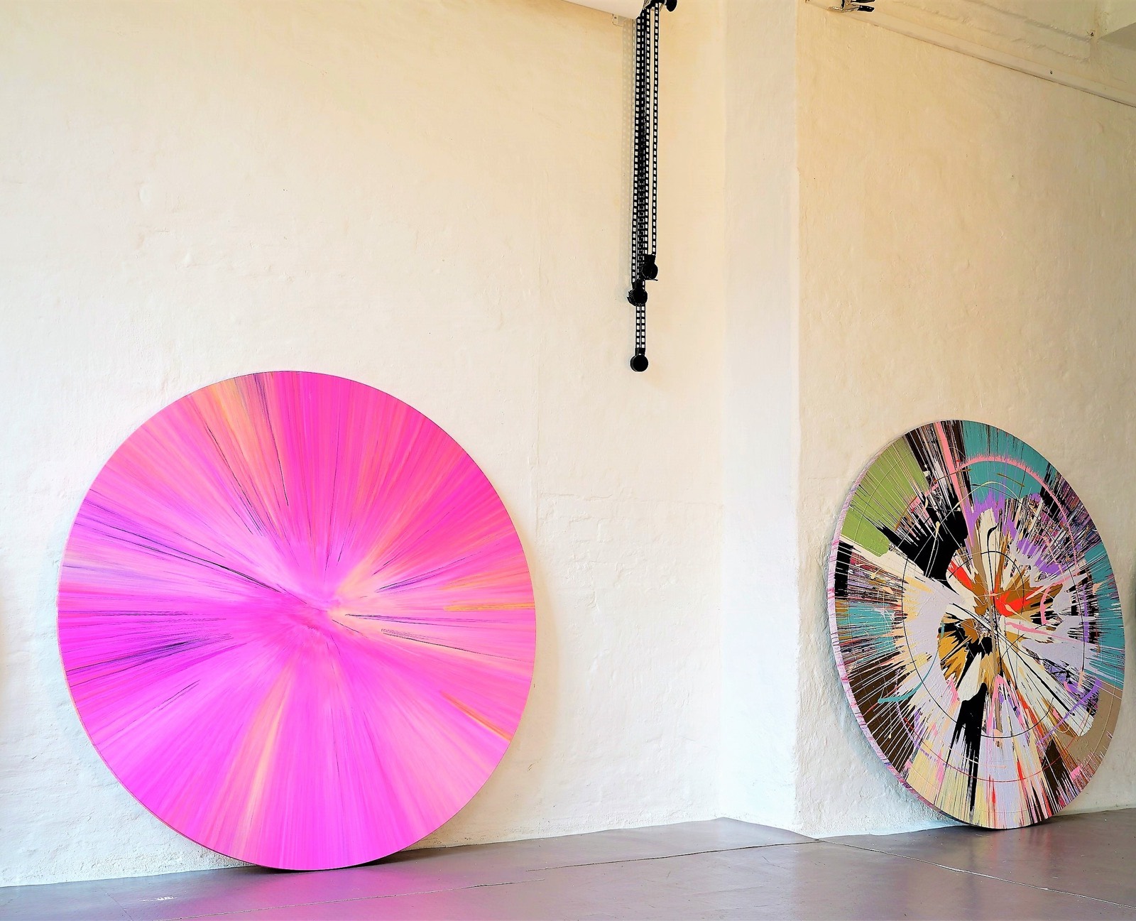 Spin painting against a pink wall